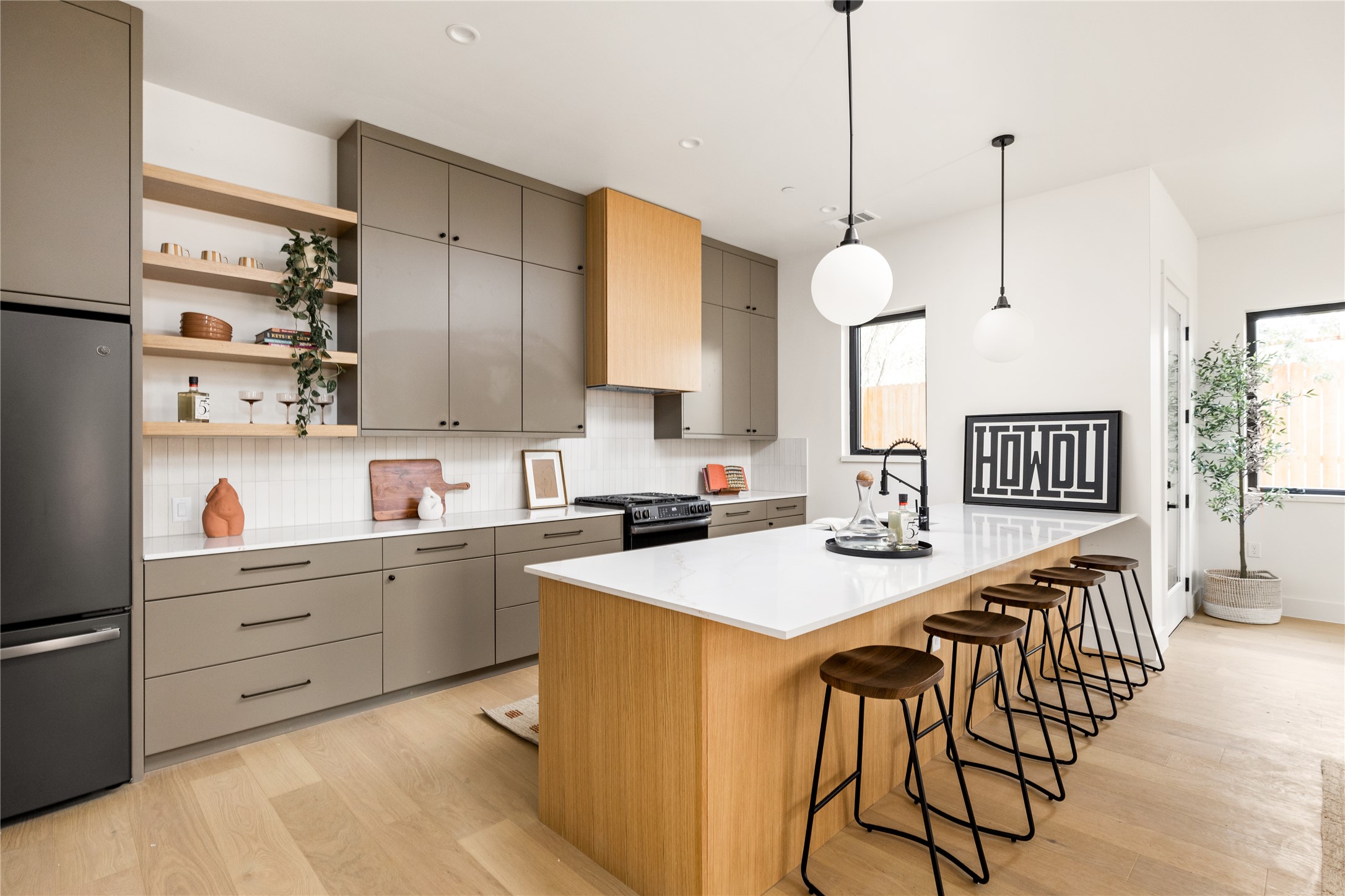 4414 South 1st Street, Unit 3 Austin, TX 78745 - Photo 20 of 39 Kitchen with open shelves, freestanding refrigerator, light wood-style floors, backsplash, and pendant lighting
