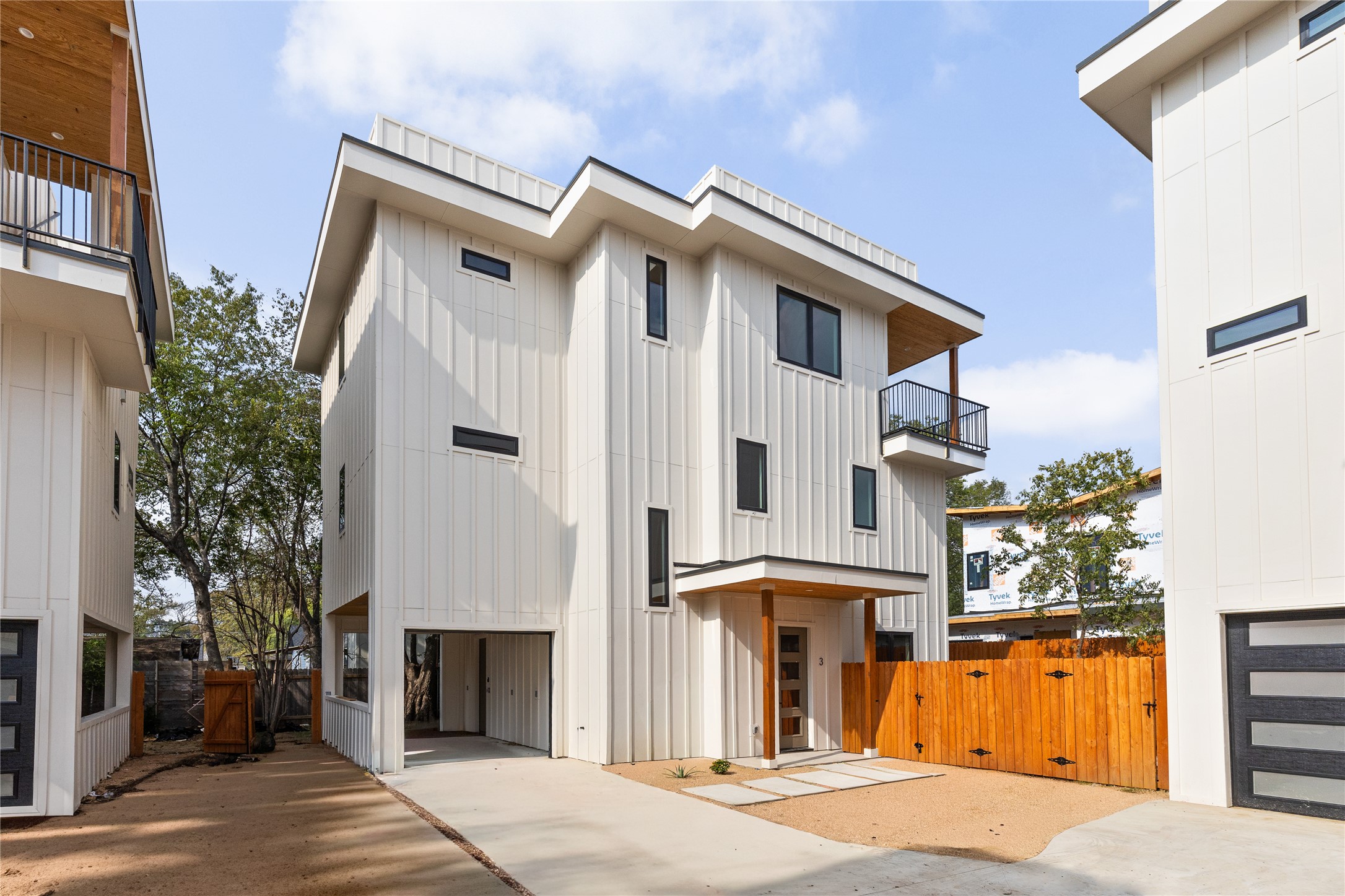 4414 South 1st Street, Unit 3 Austin, TX 78745 - Photo 28 of 39 View of front of home with a gate, board and batten siding, a balcony, and concrete driveway