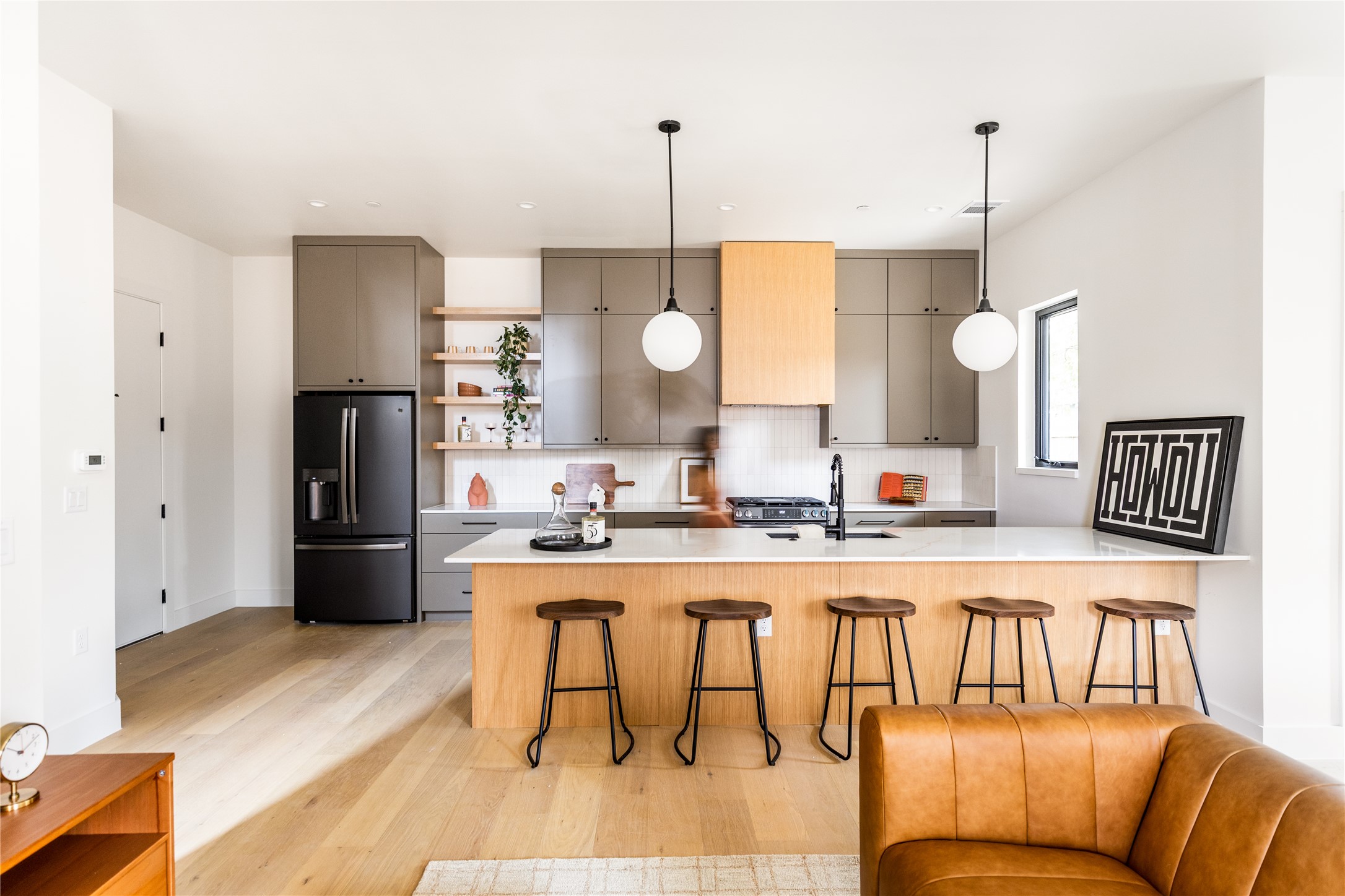 4414 South 1st Street, Unit 3 Austin, TX 78745 - Photo 3 of 39 Kitchen featuring open shelves, a kitchen bar, fridge with ice dispenser, gray cabinets, and decorative light fixtures
