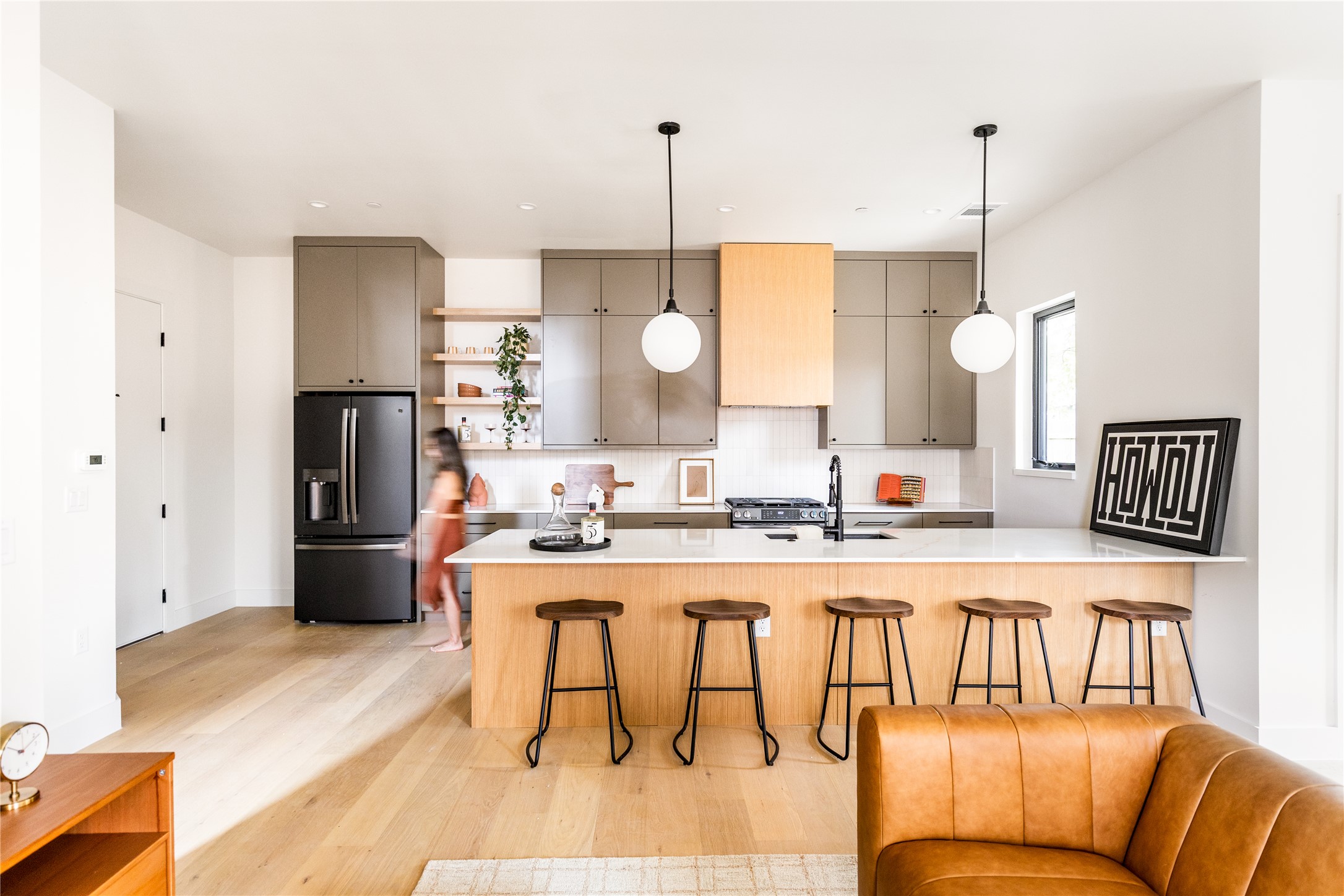 4414 South 1st Street, Unit 3 Austin, TX 78745 - Photo 4 of 39 Kitchen featuring open shelves, a kitchen breakfast bar, stainless steel appliances, pendant lighting, and light wood finished floors