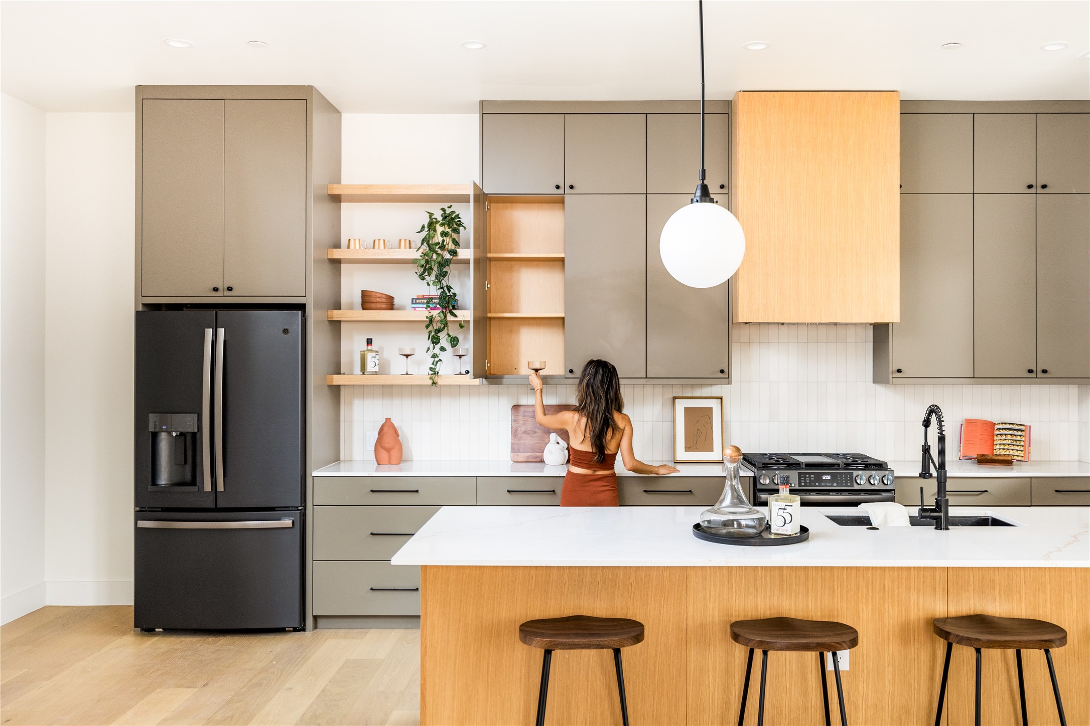 4414 South 1st Street, Unit 3 Austin, TX 78745 - Photo 8 of 39 Two tone kitchen with refrigerator with ice dispenser, open shelves, light wood-style flooring, a breakfast bar, and dual tone cabinetry