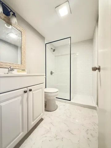 a bathroom with a shower a toilet and a sink