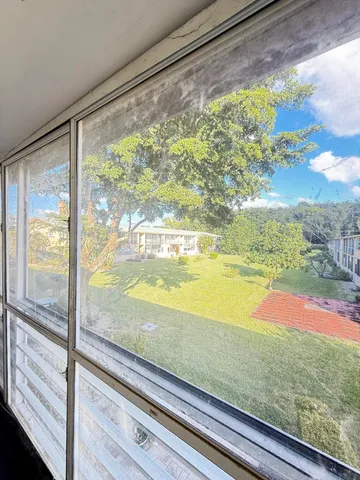 a view of a room with wooden floor and a floor to ceiling window