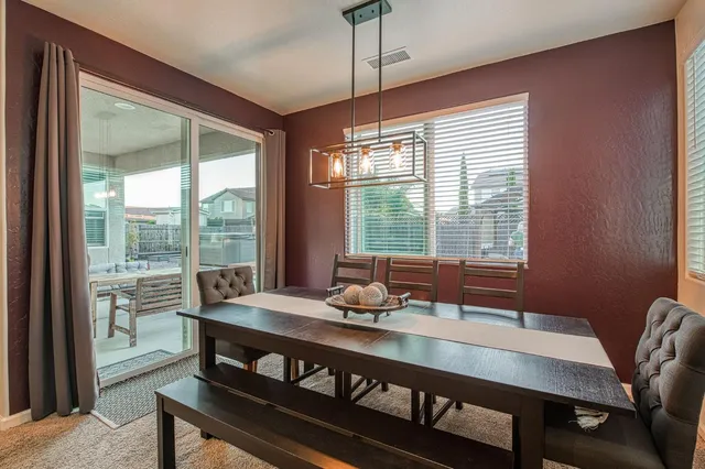 a living room with stainless steel appliances furniture a flat screen tv and kitchen view