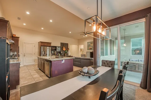 a dining hall with stainless steel appliances granite countertop a stove and a sink