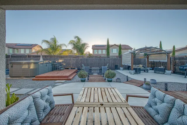 a view of a patio with couches and table and chairs with wooden floor