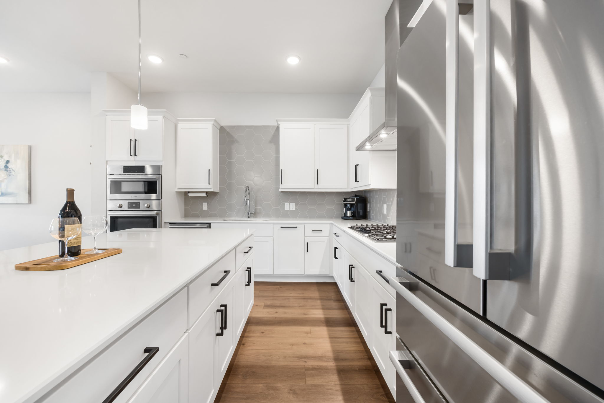 1417 Kramer Lane, Unit 14 Austin, TX 78758 - Photo 10 of 33 Kitchen featuring stainless steel appliances, white cabinets, decorative backsplash, hanging light fixtures, and dark wood-style flooring