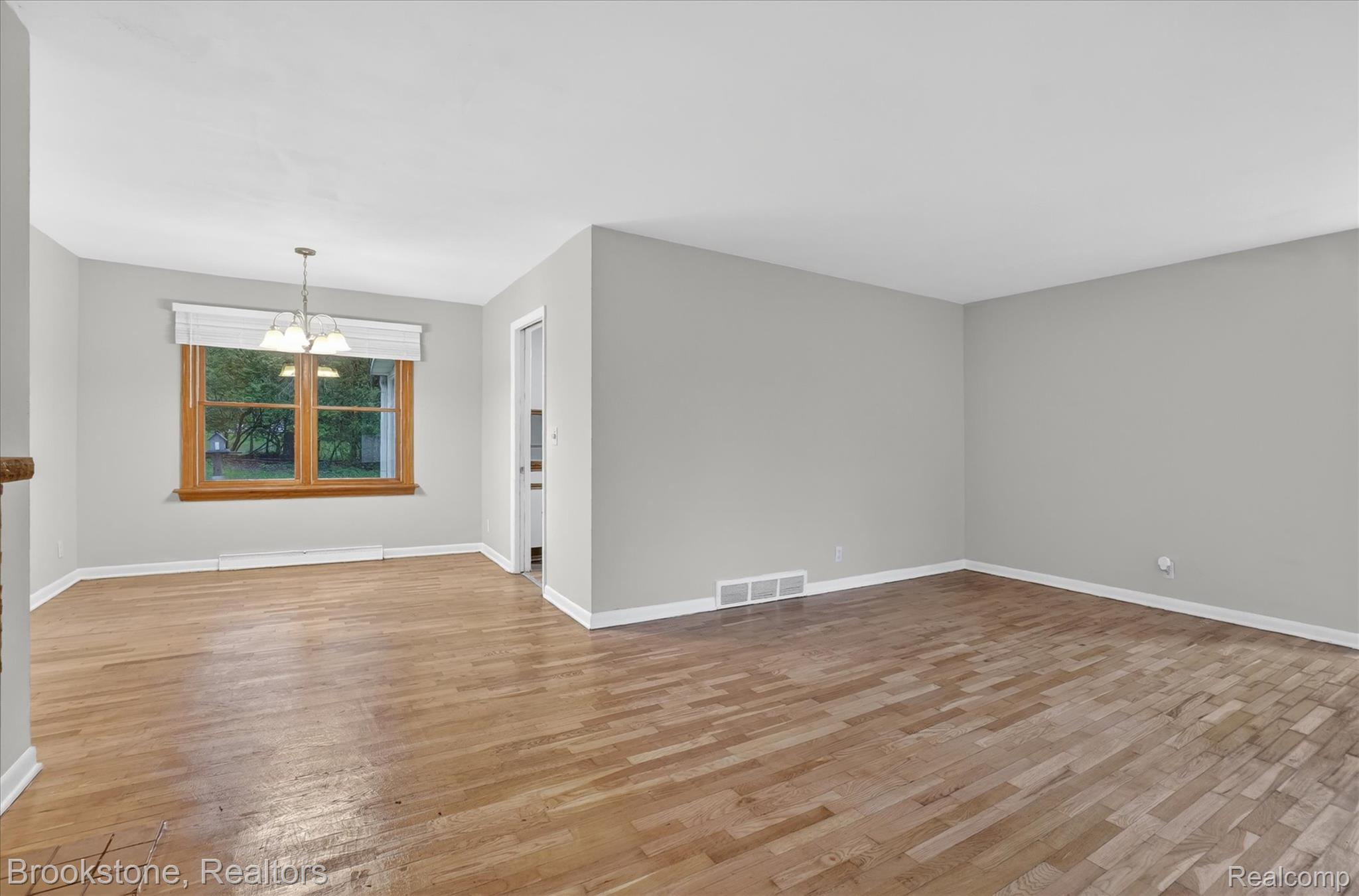 4547 Marlborough Road Okemos, MI 48864 - Photo 8 of 55 Spare room with a chandelier, light wood-style floors, and a baseboard radiator