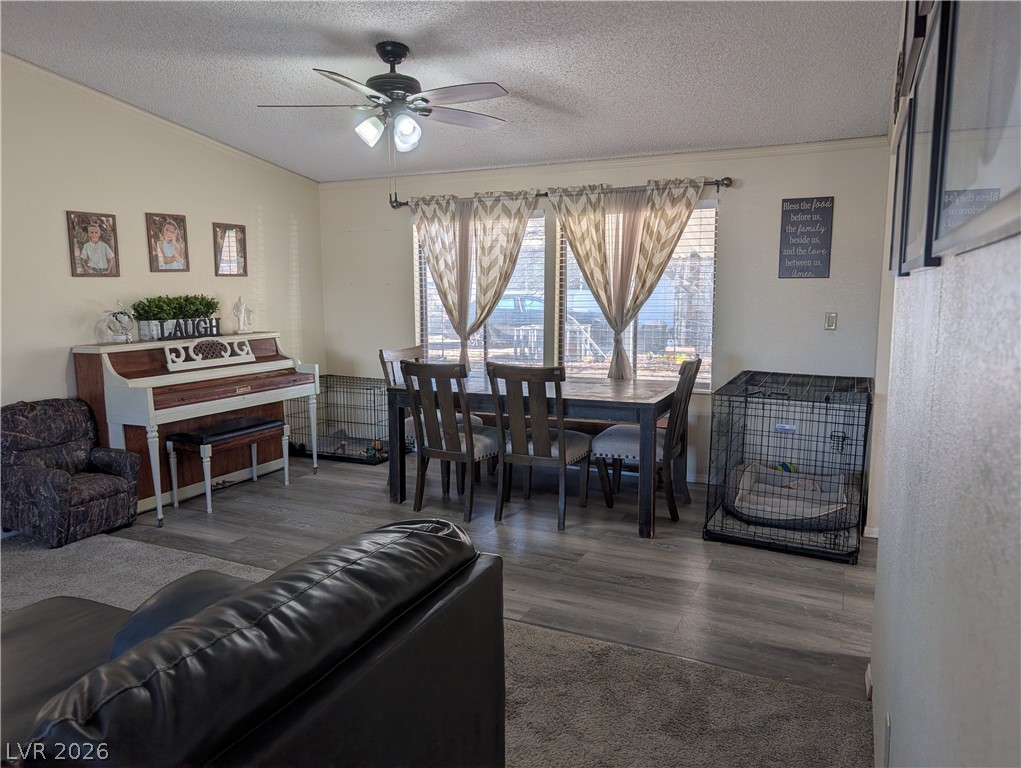 320 6th Street Panaca, NV 89042 - Photo 6 of 31 Dining area with a ceiling fan, a textured ceiling, dark wood-type flooring, and ornamental molding