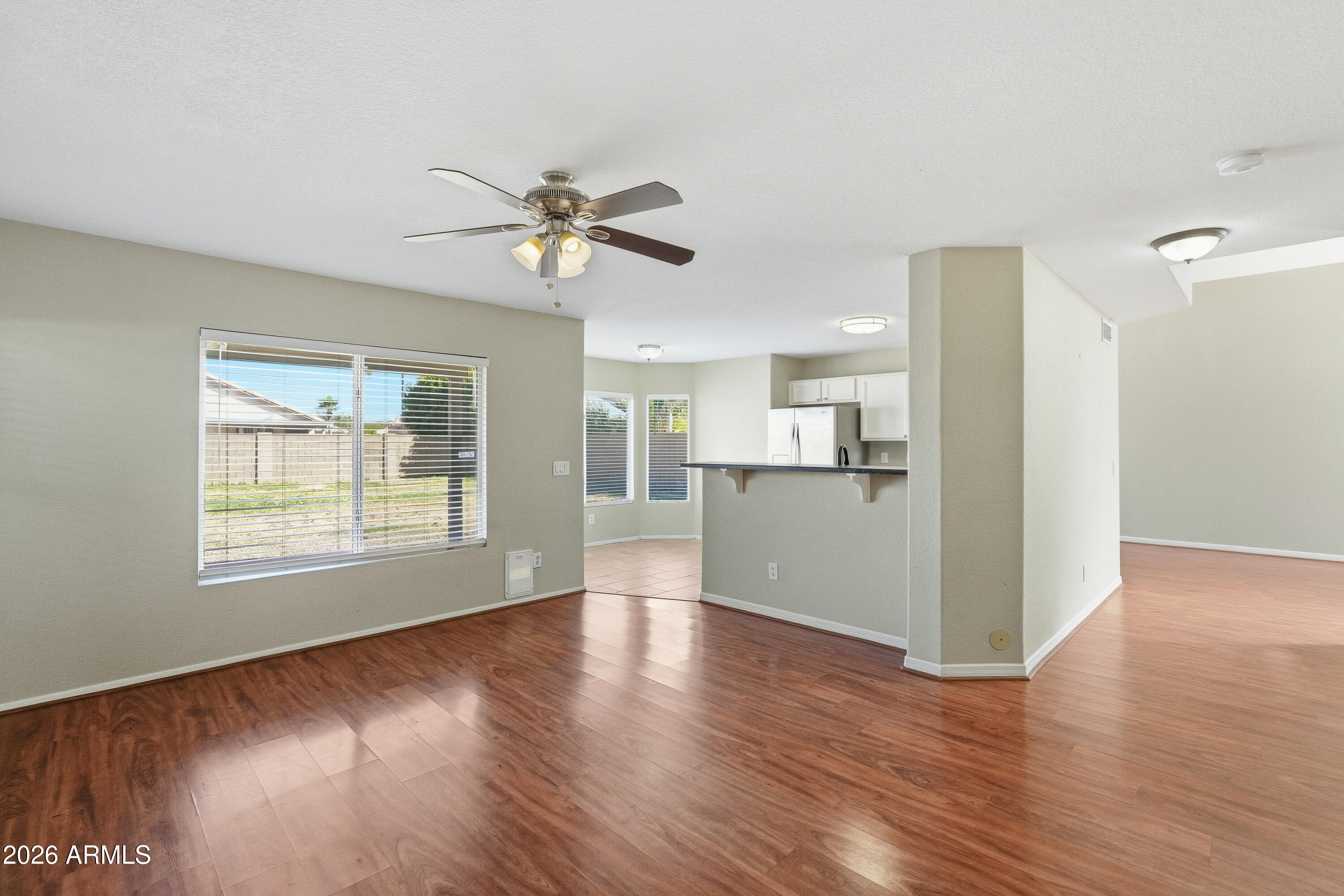 2840 East Wagoner Road Phoenix, AZ 85032 - Photo 7 of 34 a view of an empty room with a kitchen and wooden floor