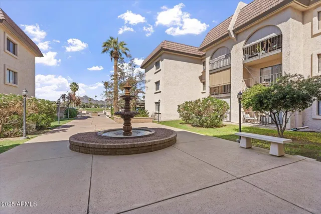 a palm tree sitting in front of a building with a yard