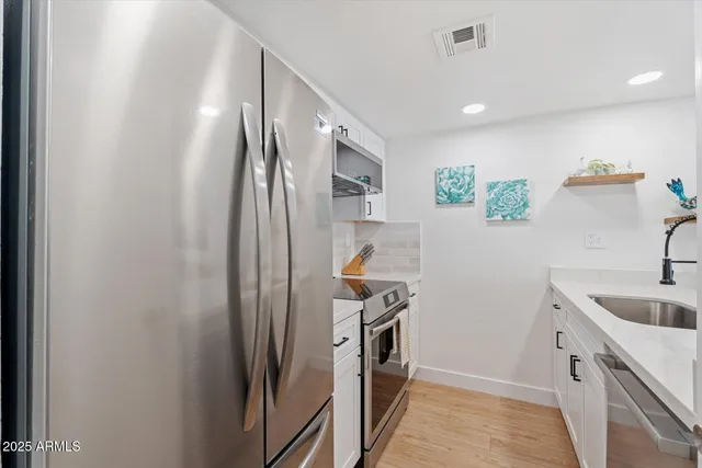 a kitchen with stainless steel appliances a sink stove and refrigerator
