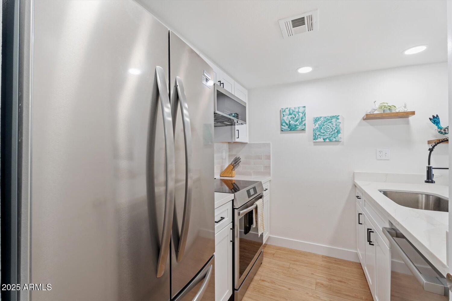 3033 East Devonshire Avenue, Unit 2003 Phoenix, AZ 85016 - Photo 9 of 32 a kitchen with a refrigerator and a sink