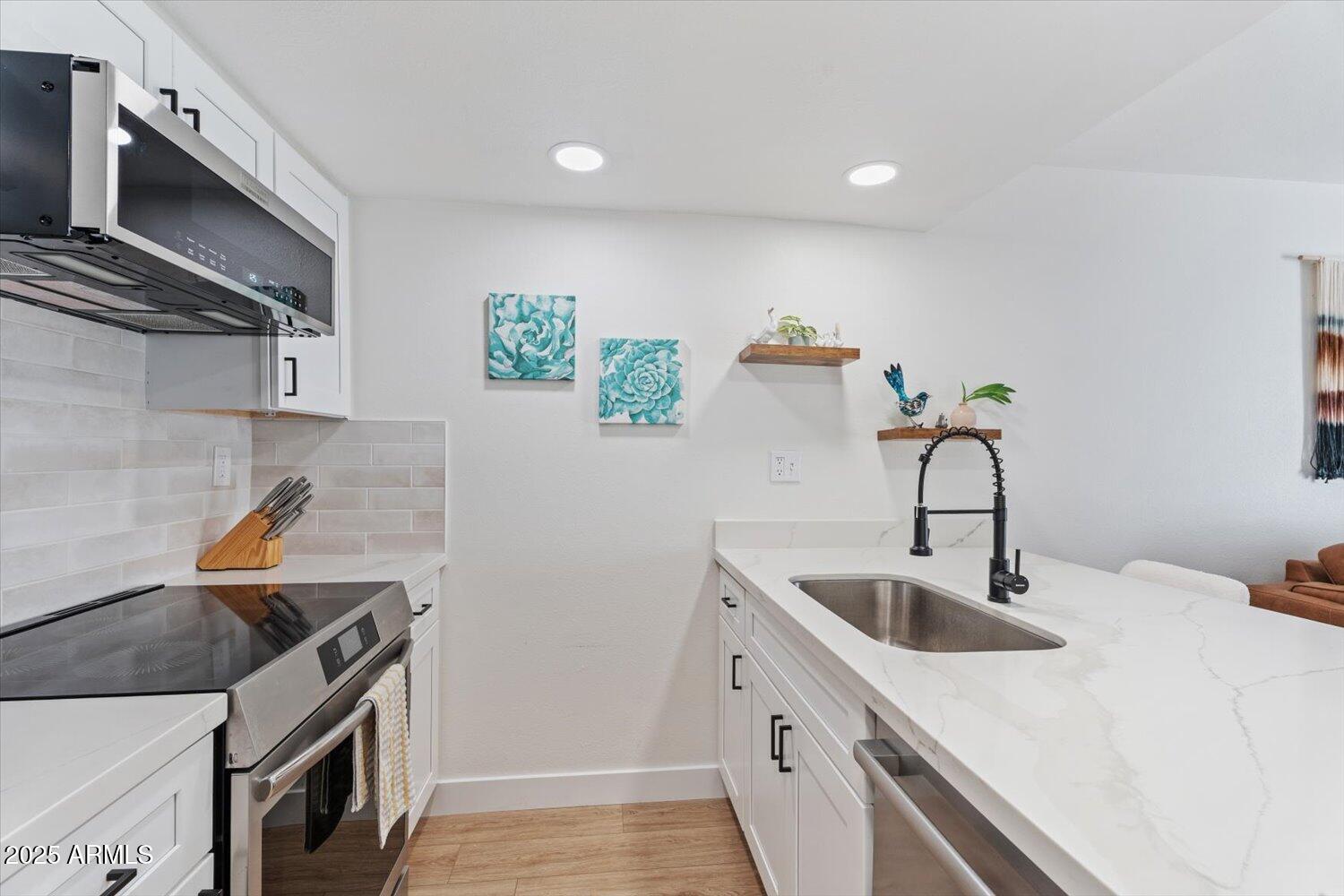 3033 East Devonshire Avenue, Unit 2003 Phoenix, AZ 85016 - Photo 8 of 32 a kitchen with stainless steel appliances a sink stove and refrigerator