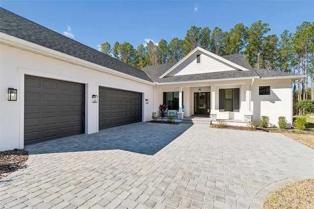 a front view of a house with yard and trees in the background