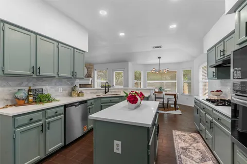 a view of a kitchen with a sink a stove and cabinets