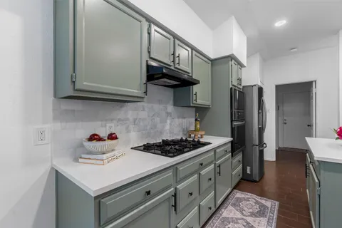 a kitchen with stainless steel appliances granite countertop a sink stove and refrigerator