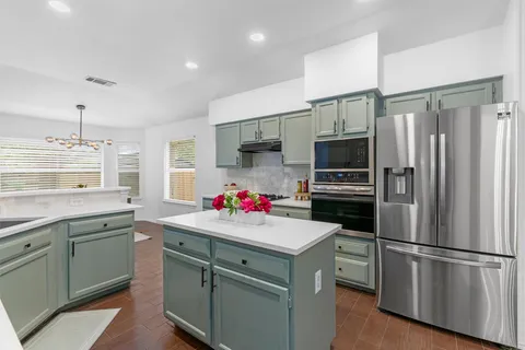 a kitchen with a sink stainless steel appliances a refrigerator and a sink