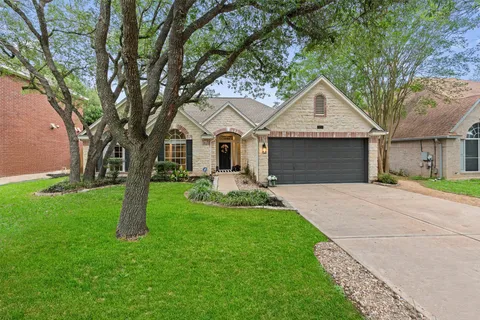 a front view of a house with yard and green space