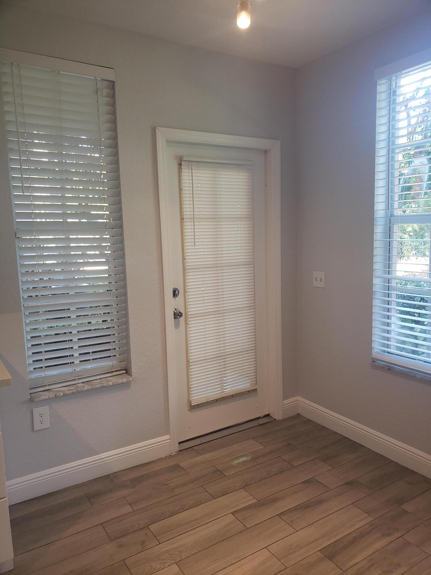 909 Belmont Place, Unit 909 Boynton Beach, FL 33436 - Photo 12 of 26 an empty room with wooden floor and windows