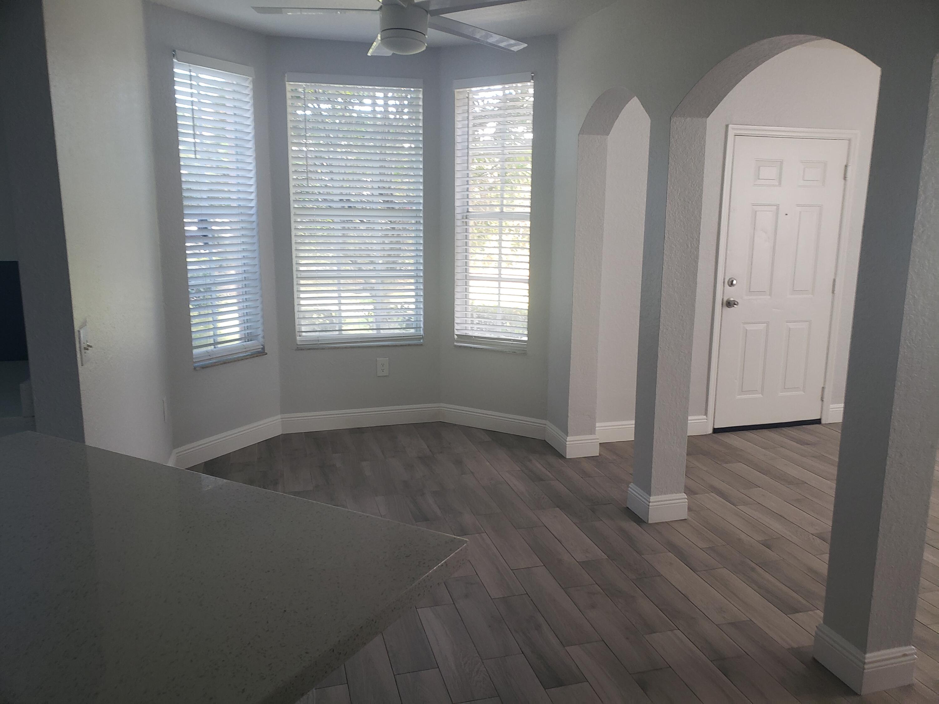909 Belmont Place, Unit 909 Boynton Beach, FL 33436 - Photo 13 of 26 an empty room with wooden floor and windows