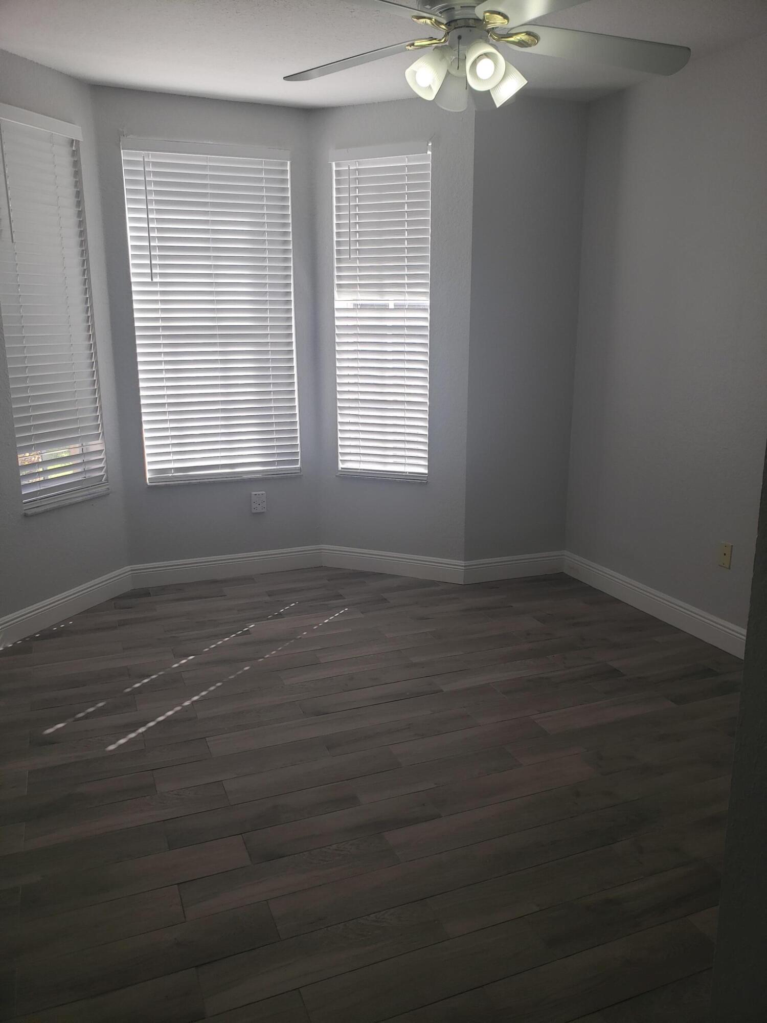 909 Belmont Place, Unit 909 Boynton Beach, FL 33436 - Photo 16 of 26 an empty room with wooden floor and windows