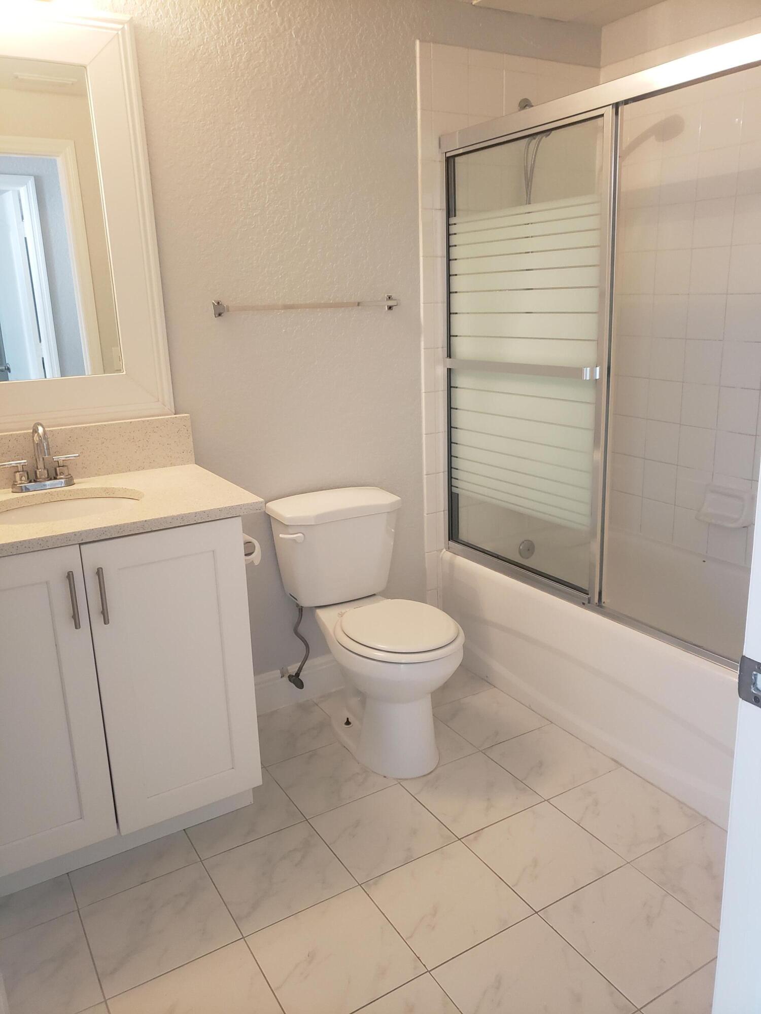 909 Belmont Place, Unit 909 Boynton Beach, FL 33436 - Photo 19 of 26 a white toilet sitting next to a bathroom sink