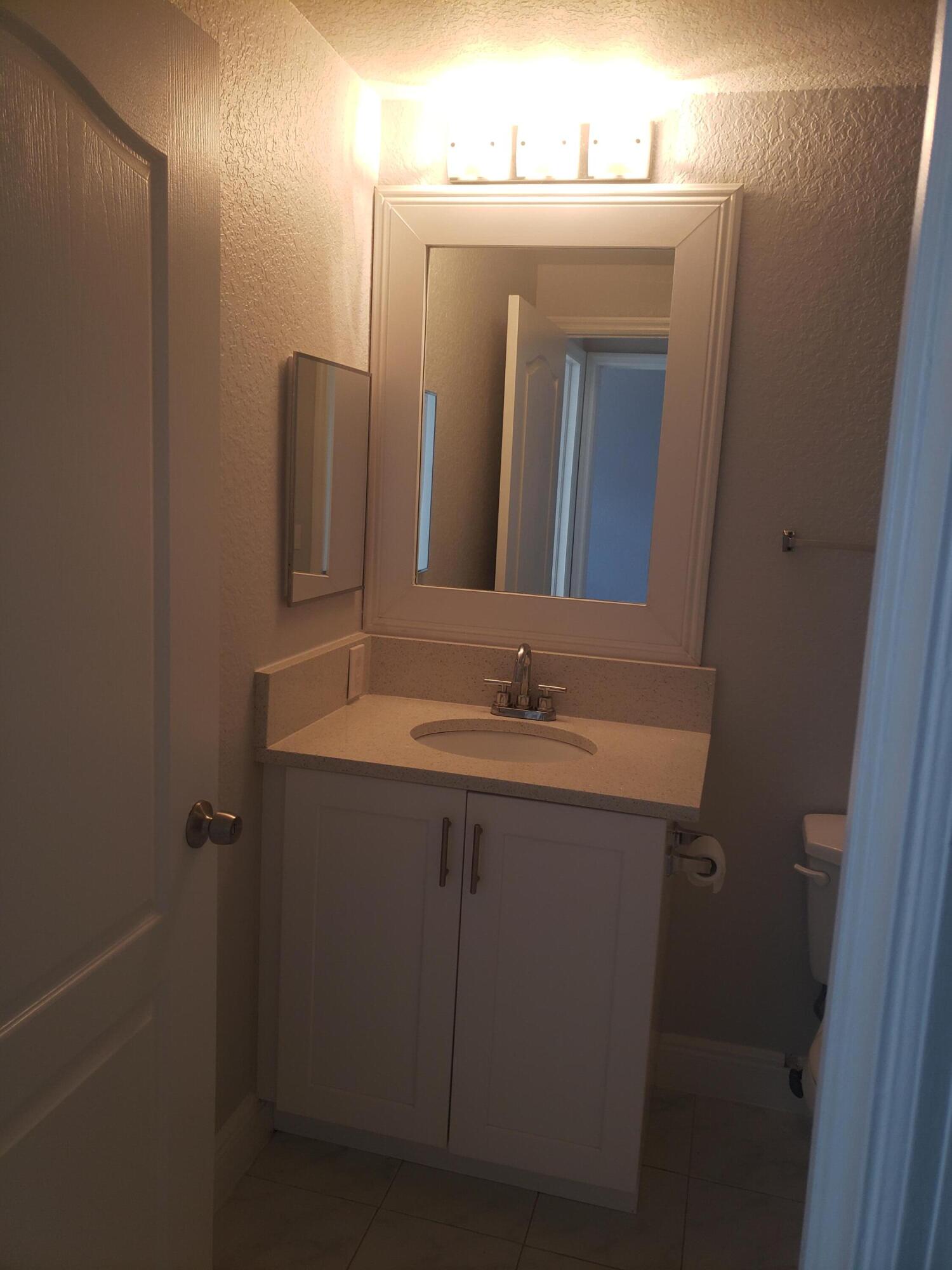 909 Belmont Place, Unit 909 Boynton Beach, FL 33436 - Photo 21 of 26 a bathroom with a sink and a mirror