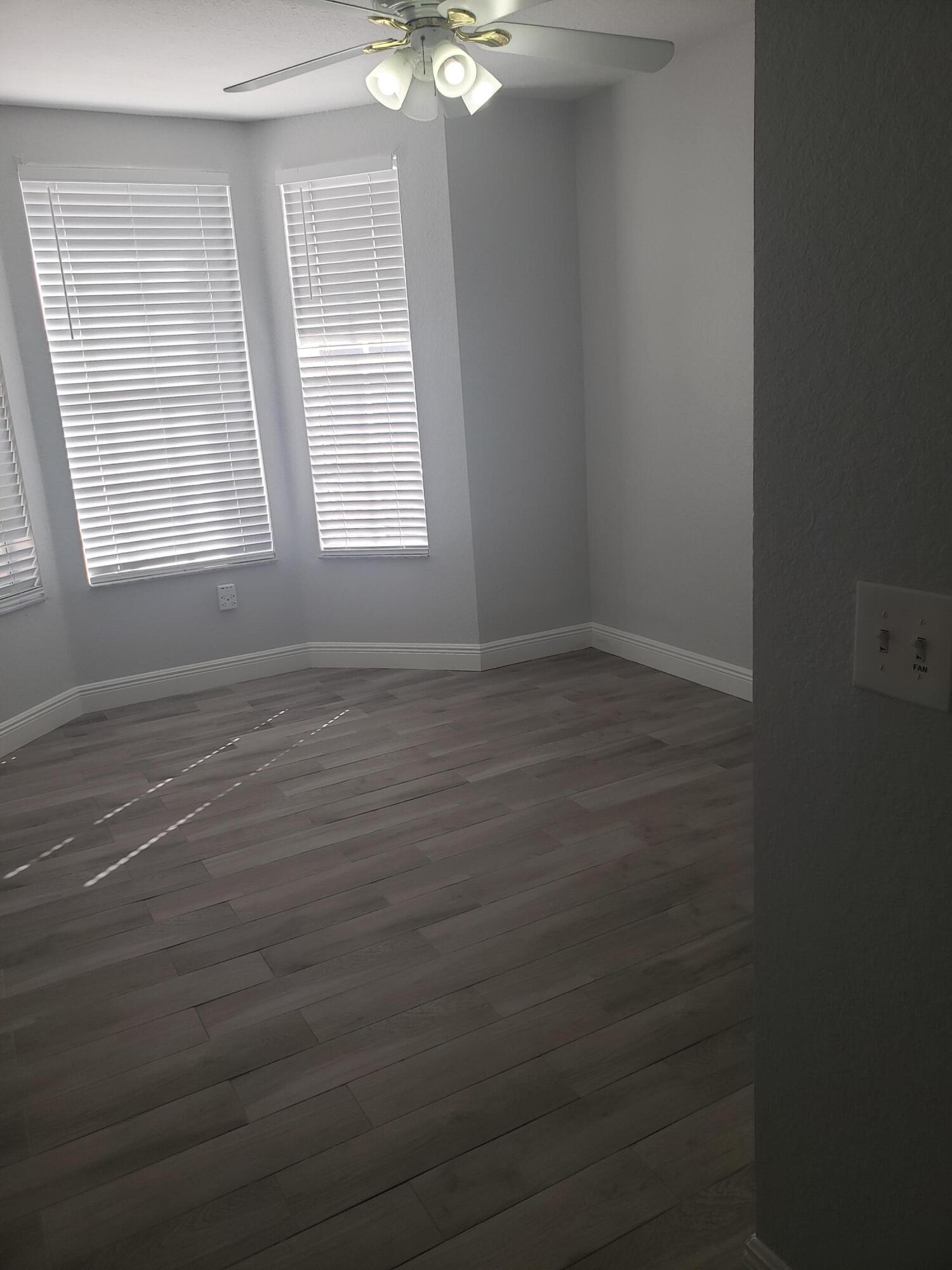 909 Belmont Place, Unit 909 Boynton Beach, FL 33436 - Photo 22 of 26 an empty room with windows and fan