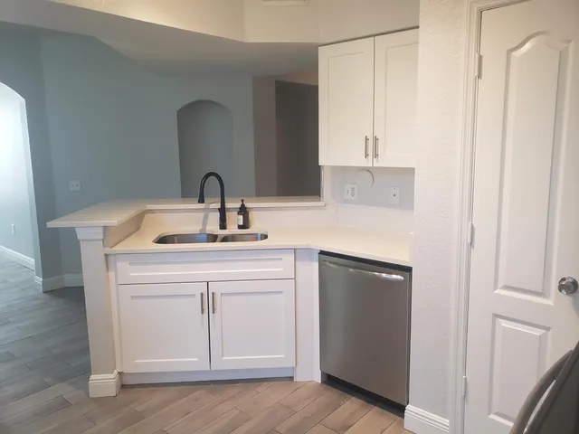 a kitchen with a sink cabinets and a wooden floor