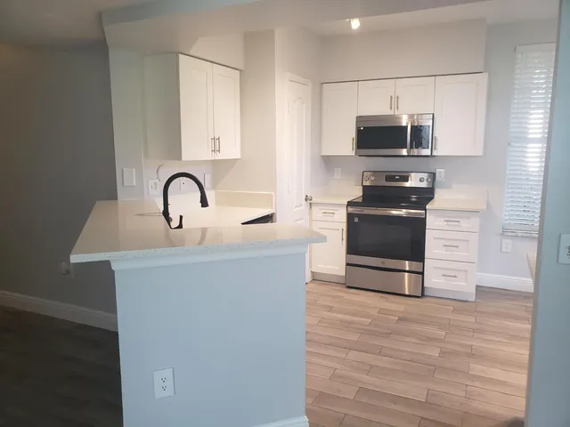 a kitchen with stainless steel appliances a stove sink and microwave