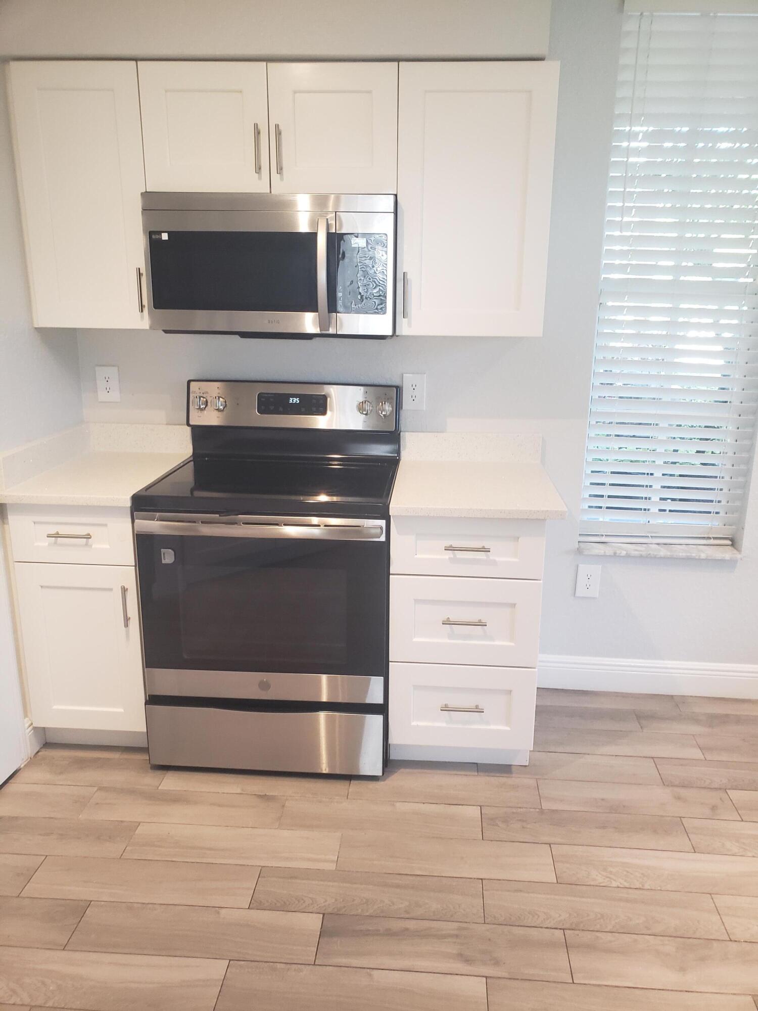 909 Belmont Place, Unit 909 Boynton Beach, FL 33436 - Photo 8 of 26 a stove top oven sitting inside of a kitchen