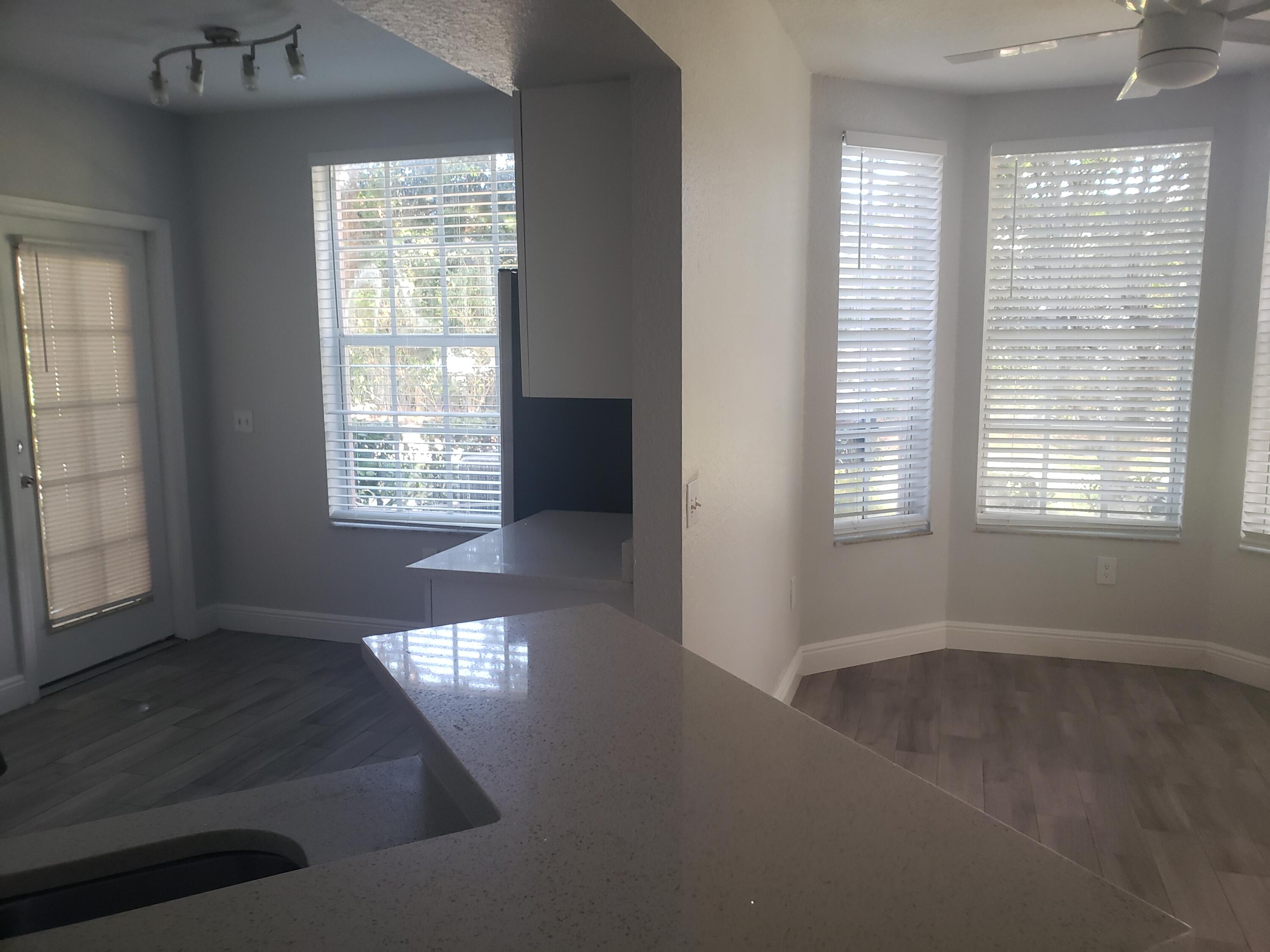 909 Belmont Place, Unit 909 Boynton Beach, FL 33436 - Photo 10 of 26 an empty room with wooden floor and windows