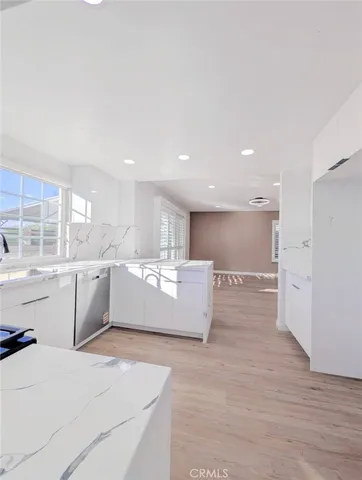 a large room with kitchen island a sink wooden floor and glass doors