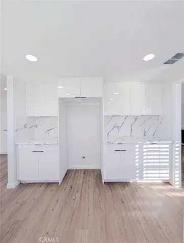 an empty room with wooden floor and white walls