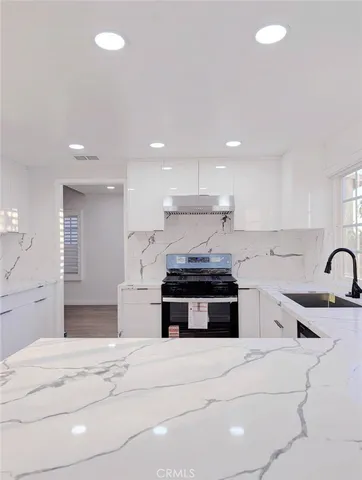 a kitchen with stainless steel appliances granite countertop a stove a sink and a microwave