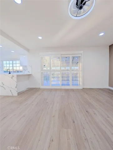 a view of empty room with wooden floor and window