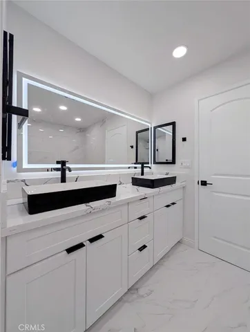 a bathroom with a sink vanity and mirror