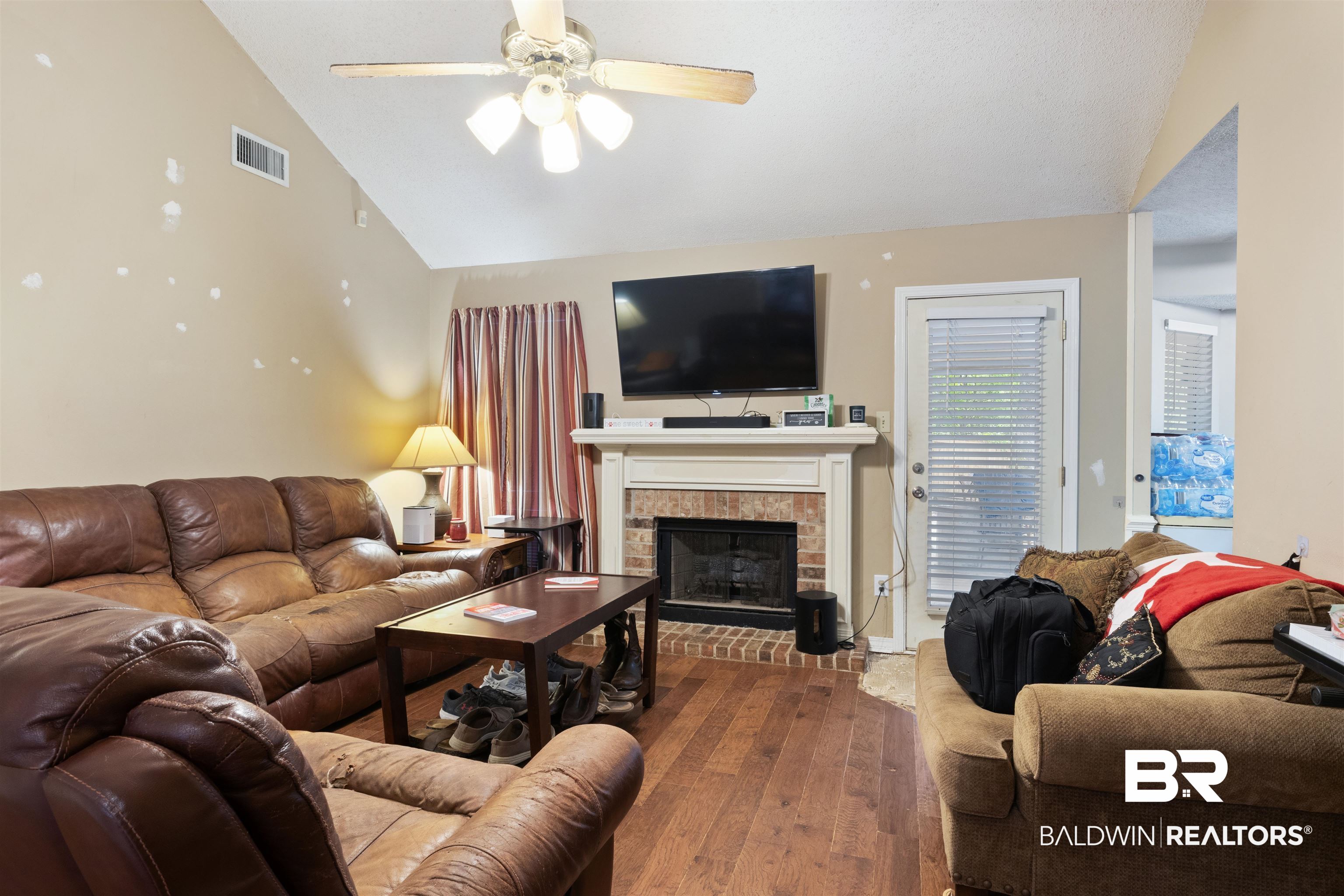 1345 Baker Court Mobile, AL 36695 - Photo 7 of 28 Living room featuring a fireplace, wood-type flooring, vaulted ceiling, and ceiling fan