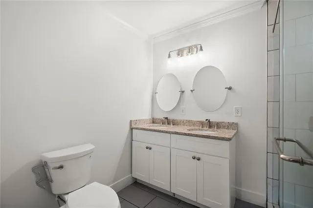 a bathroom with a granite countertop toilet a mirror and a sink
