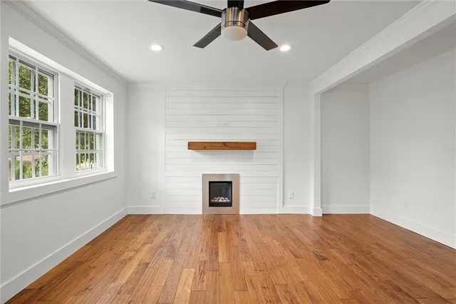 a view of empty room with wooden floor and fireplace