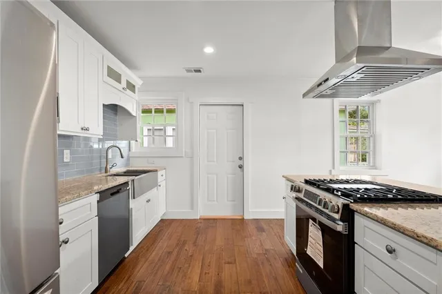 a kitchen with stainless steel appliances granite countertop a sink stove and cabinets