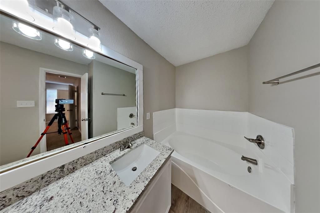 1924 Overland Street Fort Worth, TX 76131 - Photo 11 of 27 a bathroom with a tub a sink and mirror