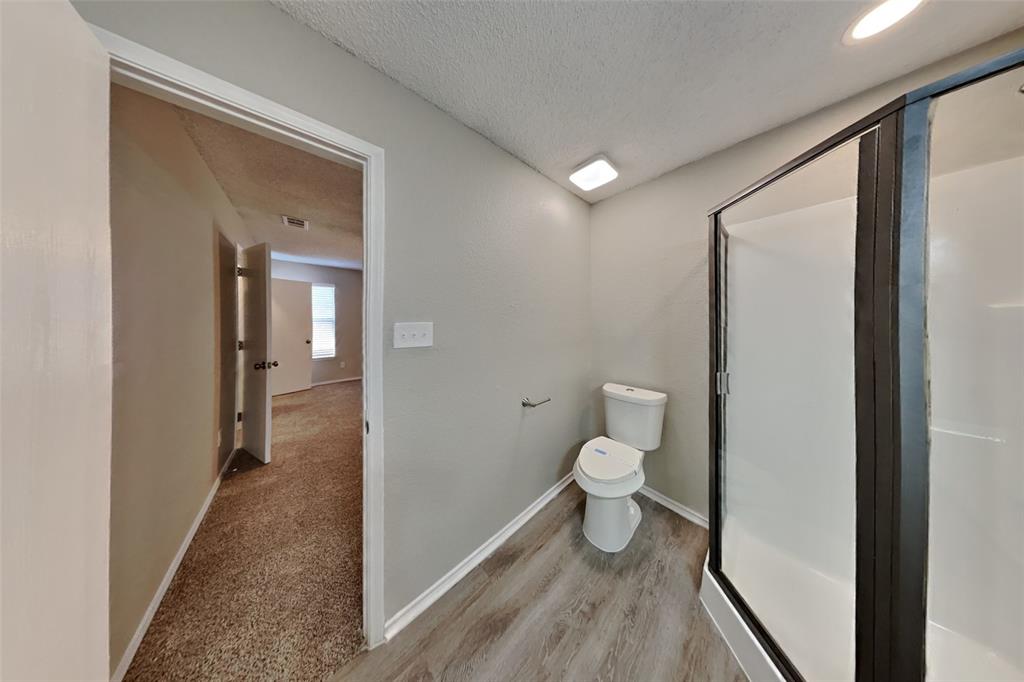 1924 Overland Street Fort Worth, TX 76131 - Photo 13 of 27 a bathroom with a toilet and a shower