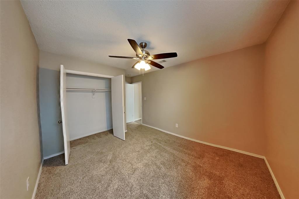 1924 Overland Street Fort Worth, TX 76131 - Photo 17 of 27 an empty room with closet and ceiling fan