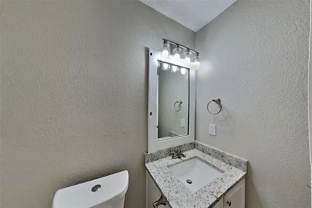 a bathroom with a granite countertop sink a mirror and shower