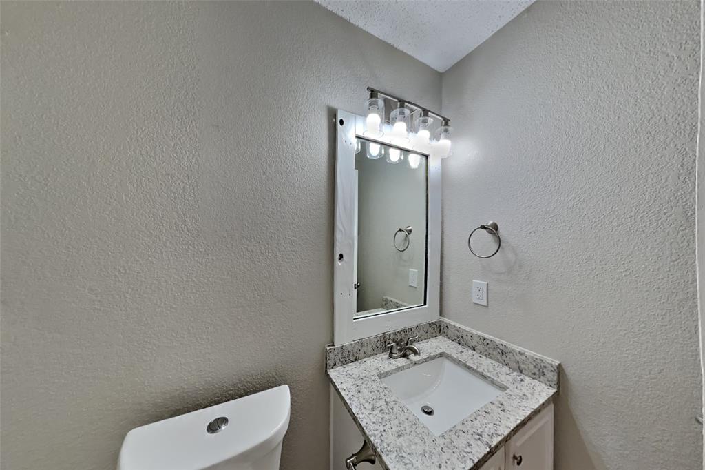 1924 Overland Street Fort Worth, TX 76131 - Photo 20 of 27 a bathroom with a granite countertop sink a mirror and shower