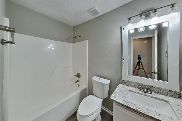 a bathroom with a granite countertop sink toilet and shower