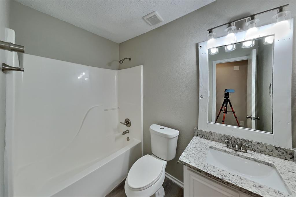 1924 Overland Street Fort Worth, TX 76131 - Photo 21 of 27 a bathroom with a granite countertop sink toilet and shower