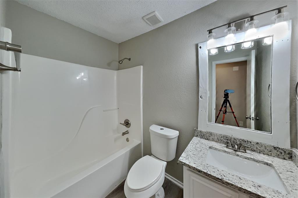1924 Overland Street Fort Worth, TX 76131 - Photo 22 of 27 a bathroom with a granite countertop sink toilet and shower